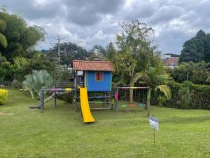 a playground with a small house and a slide at F111- Apartamento cerca al Club Campestre con piscina in La Tebaida