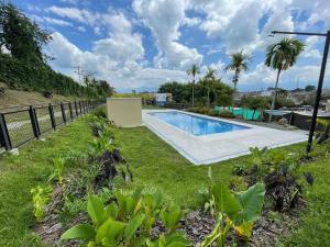 a backyard with a swimming pool and a fence at F111- Apartamento cerca al Club Campestre con piscina in La Tebaida