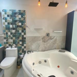 a bathroom with a white tub and a toilet at Casa - Habitaciones en Roldanillo Valle in Roldanillo