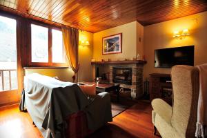 a living room with a fireplace and a tv at Cal Berg, Acogedor apartamento en Garòs cerca de Baqueira by Eth Flòc in Garós