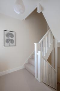 チェルムスフォードにあるModern 2 bed town house quiet street near stationの壁に木が飾られた家の白い階段