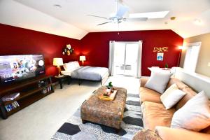 a living room with red walls and a couch and a bed at Large 3 Bedroom, Tremont House, minutes from everything!! in The Angle