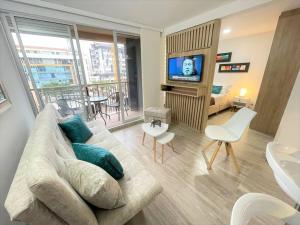 Una sala de estar con un sofá, un televisor y una mesa. en M510- Apartaestudio en Av19 Norte con parqueadero, en Armenia