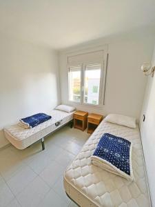two beds in a room with a window at Apartamento de 3 habitaciones en el centro in L'Escala