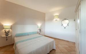 a bedroom with a bed and two lights on the wall at Vignola Baia Dei Mirti M3 in Vignola Mare