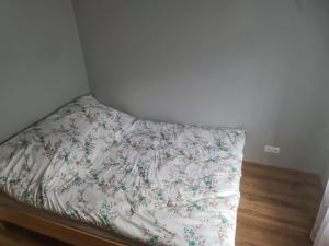 a bed in a room with a floral bedsheet at Apartament mieszkanie do wynajęcia Justyna in Walim