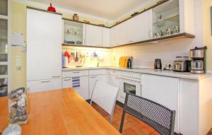 Una cocina con gabinetes blancos y una mesa y sillas. en Ferienwohnung Prerow Ostseebad, en Prerow