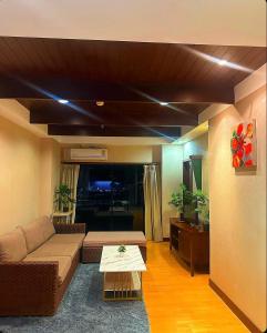 a living room with a couch and a table at Patong Tower Apartment - AMP in Patong Beach
