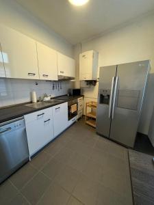 Una cocina con gabinetes blancos y electrodomésticos de acero inoxidable. en Best Frankfurt Apartments, en Frankfurt 16 fotos más