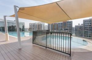 a balcony with a swimming pool on a building at Luxury apartment in Sobha Hartland Waves near Dubai mall and Burj Khalifa in Dubai