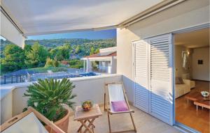 a balcony of a house with a table and a chair at Holiday Home Primosten-Dolac With Outdoor Pool in Podgreben