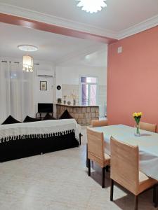 a bedroom with a bed and a table and chairs at Maison RKA in Bejaïa