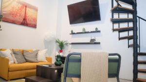 a living room with a couch and a tv on a wall at Old San Juan Apartment in San Juan