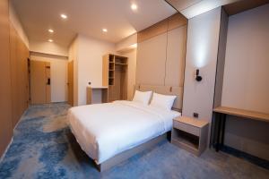 a bedroom with a large white bed in a room at RumHotel in Bishkek