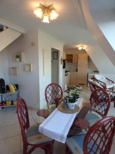 a dining room with a table and chairs at Escapade Sarah, appartement duplex in Fort-Mahon-Plage +14 photos
