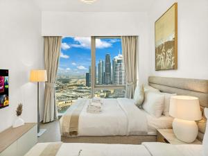 a bedroom with a large white bed and a large window at SmartStay at Grande Signature - Burj Khalifa View - 5 min Dubai Mall - Downtown Dubai - Brand New Luxury Apartments in Dubai +108 photos
