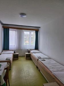 a room with three beds and a window at Ubytování Hilšer in Potštát