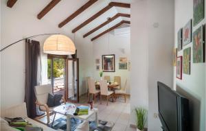 a living room with a tv and a table at Cozy Home In Vrbanj With Sauna in Basina