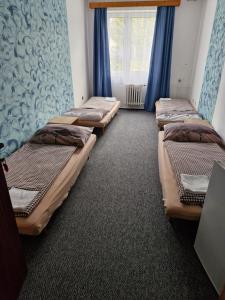 a row of beds in a room with a window at Ubytování Hilšer in Potštát