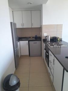 una piccola cucina con armadietti e elettrodomestici bianchi di Serenity 905 a Durban Altre 21 foto