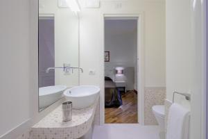 Un baño blanco con dos lavabos y un espejo. en Lory House, en Roma