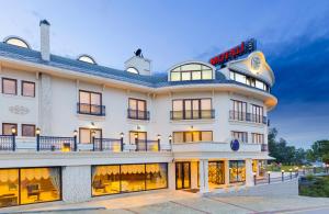 a large white building with a sign on it at Motali Life Hotel in Masukiye