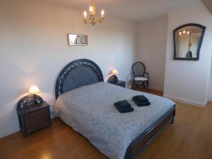 a bedroom with a bed with two black towels on it at Escapade Sarah, appartement duplex in Fort-Mahon-Plage