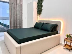 Un dormitorio con una cama con almohadas verdes. en Unitá Praia Grande Boqueirão, en Praia Grande 14 fotos más