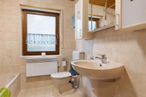 a bathroom with a sink and a toilet and a window at Ferienwohnung Bender in Sinsheim +14 photos