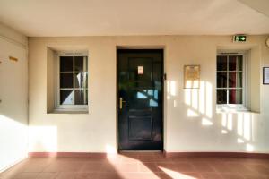 a black door in a building with two windows at Résidence Le Parc d'Arradoy - maeva Home - Appartement 2 pièces 4 personnes - Confort MAE-5971 in Uhart-Cize +13 photos