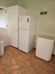 a kitchen with a white refrigerator in a room at Jardin Damon in Soufrière