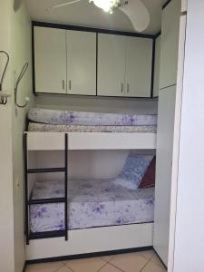 a room with two bunk beds with white cabinets at Espaço SOSSEGO in Guarujá +31 photos