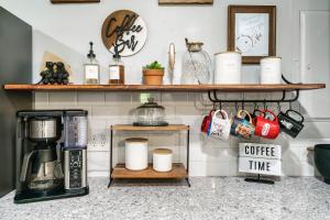 a kitchen counter with a shelf with cups and a coffee maker at Cozy Mountain Cabin, Sleeps 8, Mini Golf, Hot Tub, Coffee Bar! in Sevierville