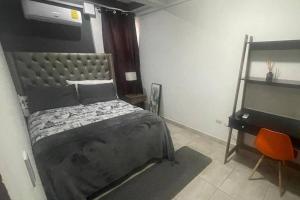 um quarto com uma cama e uma escrivaninha em Pequeño y acogedor con 2 Habitaciones em Tegucigalpa