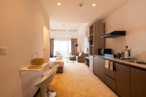 a kitchen and a living room with a couch at Negombo Beach - The Breeze by Roshi in Negombo