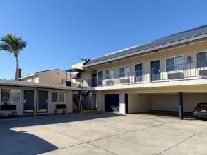 a building with a palm tree and a parking lot at Hiland Motel in Long Beach