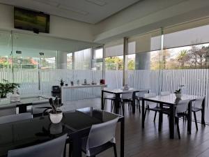 a dining room with tables and chairs and windows at Alexander Boulevard - Apartamento en Piso alto in Punta del Este