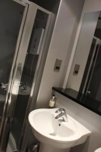 W łazience znajduje się umywalka i lustro. w obiekcie Newmachar Hotel w mieście Newmacher