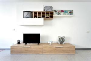 a living room with a television on a wooden table at Estudio completo piscina y playa en Candelaria Tenerife in Candelaria