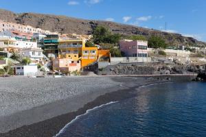 a group of buildings on a beach next to the water at Estudio completo piscina y playa en Candelaria Tenerife in Candelaria
