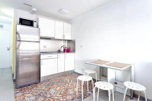 a kitchen with a stainless steel refrigerator and stools at Estudio completo piscina y playa en Candelaria Tenerife in Candelaria