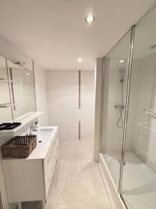 Un baño blanco con ducha y lavabo. en Villa Panouse, en Marsella
