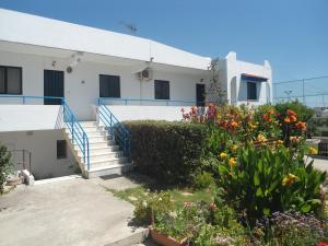 a building with stairs and flowers in front of it at Evi Apartments And Studios in Theologos