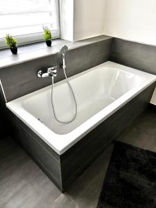 a white bath tub in a bathroom with a window at No 20 - gemütliche 2 Zimmer Whg, Küche, Balkon, Badewanne, Parkplatz in Leinefelde