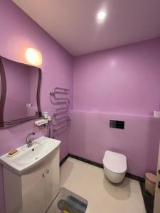 a purple bathroom with a toilet and a sink at Comfortable Townhouse in Vilnius +29 photos