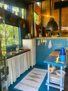 una cucina blu con lavandino e frigorifero di Eco Cabana a 150 metros da praia e centrinho a Parati