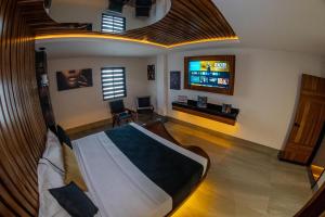 ein Schlafzimmer mit einem Bett und einem Fernseher in der Unterkunft Switch Auto Hotel in El Nido