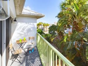 a balcony with chairs and a table and palm trees at Coastal Bliss Retreat - Beach Vibes & Rockets in Cocoa Beach