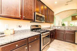 a kitchen with wooden cabinets and a stove top oven at Aloha Breeze Pet Friendly House Near Beach in Myrtle Beach