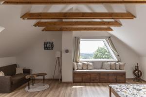 a living room with a couch and a window at Chalúpka Polom in Hnúšťa